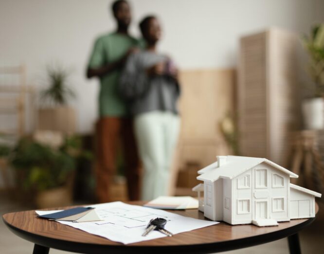 nouvelles-cles-de-la-maison-et-plan-sur-table-avec-couple-defocalise nouvelles-cles-de-la-maison-et-plan-sur-table-avec-couple-defocalise